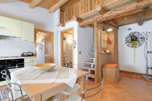 cocina y comedor con mesa y sillas en Tirso Apartament en Castello di Fiemme