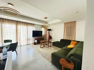 a living room with a green couch and a television at FINELINE Villa in Limassol
