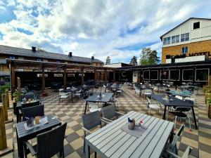 a patio with tables and chairs and a building at Sidsjö Hotell & Konferens in Sundsvall