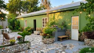 a garden with a green building with a patio at PINE-APPALE Riverside Resort in Ấp Kế Mỹ +25 photos