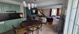 a kitchen and living room with a table and chairs at Les Preuses, un Grand Cru de Chablis avec jacuzzi in Fontenay-près-Chablis
