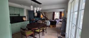 a kitchen and living room with a table and chairs at Les Preuses, un Grand Cru de Chablis avec jacuzzi in Fontenay-près-Chablis