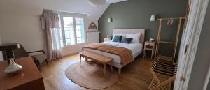 a bedroom with a bed and a table and a window at Les Preuses, un Grand Cru de Chablis avec jacuzzi in Fontenay-près-Chablis