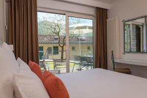 a bedroom with a bed and a large window at Parco San Marco Lifestyle Beach Resort in Porlezza +43 photos
