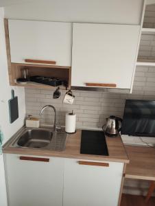 a kitchen with white cabinets and a sink at Aquamarine Centrale in Kavála +12 photos