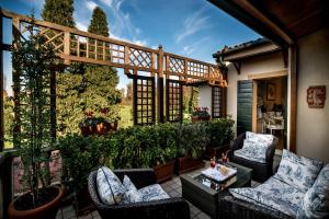 un patio con sillas, una mesa y una valla en Romantik Hotel Villa Margherita, en Mira