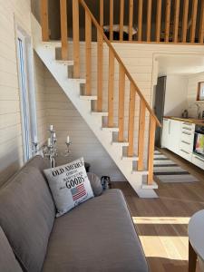 a living room with a couch and a staircase at Lilla Risingegården in Risinge