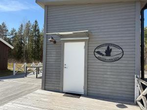 a building with a white door and a sign on it at Lilla Risingegården in Risinge +1 photo