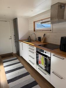 a small kitchen with white cabinets and a sink at Lilla Risingegården in Risinge