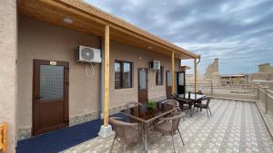 a patio with tables and chairs on a balcony at Khiva Mahliyo in Khiva
