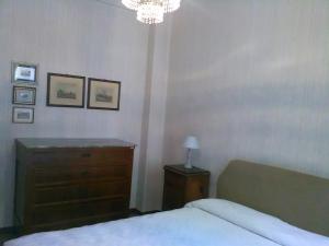 a bedroom with a bed and a dresser and a chandelier at Casa dell'ulivo in Moneglia