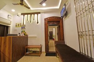 a lobby with a waiting room with a tv on the wall at Hotel De Lux Splendid in Pondicherry +12 photos
