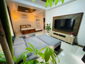 a living room with a couch and a television at Beachfront Studio with Cozy and Spacious Balcony in Baling