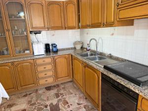 a kitchen with wooden cabinets and a sink at Villa OLGA in Ginosa Marina
