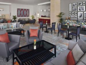 a lobby with couches and chairs and a table at Mövenpick Hotel & Apartments Bur Dubai in Dubai