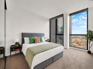 a bedroom with a large bed and large windows at Zen Grand 3 Bedroom Residences 120m2 with up to 7 Separate Beds in Melbourne