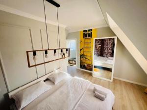 a bedroom with a large white bed and a mirror at Doinita House in Borşa