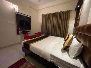 a bedroom with a large bed and a television at Hotel Durga International in Udupi