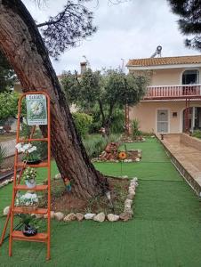 a green lawn with a ladder next to a tree at Villa Evenik in Eretria