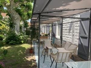 a screened in porch with chairs and a table at Entre Mer et Pins in Saint-Julien-en-Born