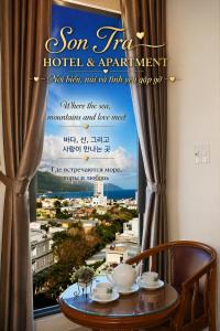 a window with a sign for a hotel and apartment at Son Tra Green Hotel & Apartment - near the My Khe beach, Son Tra Peninsula, Linh Ung Pagoda in Danang