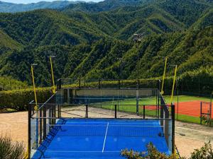 a tennis court with mountains in the background at I Cancelli -Mugello Park Family Village in Palazzuolo sul Senio