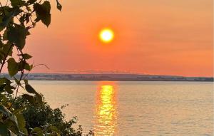 a sunset over the water with the sun in the sky at Nice Home In Gränna With House Sea View in Gränna