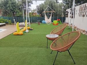 a playground with two chairs and swings on the grass at Villa Evenik in Eretria