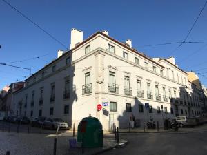 ein großes weißes Gebäude an der Straßenseite in der Unterkunft Lisbon Bairro Alto Apartments Free Parking in Lissabon