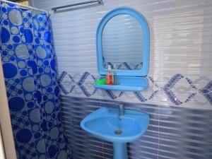 a bathroom with a blue sink and a mirror at Ali guest house Samarkand in Aman-Kutan