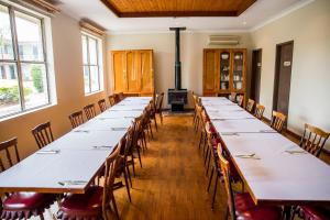 a row of tables in a room with windows at Lilac City Motor Inn & Steakhouse in Goulburn