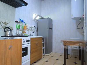 a kitchen with a white stove and a refrigerator at Ali guest house Samarkand in Aman-Kutan