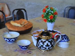 a table with a tea pot and a plate of food at Ali guest house Samarkand in Aman-Kutan +36 photos