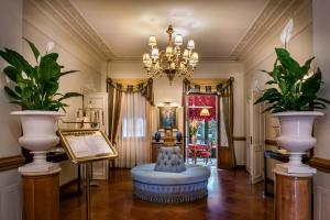 un soggiorno con lampadario pendente e sedia blu di Romantik Hotel Villa Margherita a Mira
