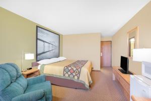 a hotel room with a bed and a tv at Super 8 by Wyndham Mt Pleasant in Mount Pleasant