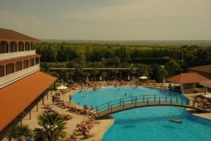 a large swimming pool with a bridge and people in it at Academy by Ambassadori in Kachretʼi
