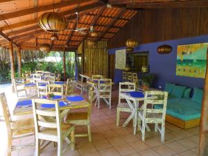 a restaurant with tables and chairs and a couch at Indigo Yoga Surf Resort in Mal País