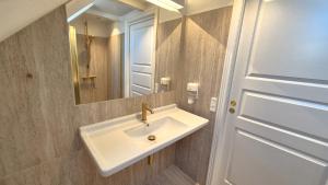 un bagno con lavandino bianco e specchio di Jacobs Hotel a Ringkøbing Altre 34 foto