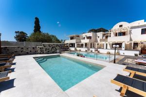 a swimming pool in front of a building at Birds Villa Apartments with Heated Pool - Including Car and Breakfast in Perissa