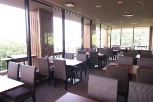 un comedor con mesas, sillas y ventanas en Breezbay Seaside Resort Matsushima, en Matsushima