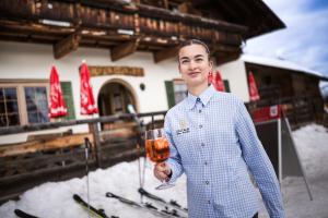 a woman is holding a glass of wine at Galtalm in Fulpmes +14 photos