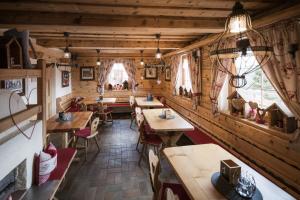 a restaurant with wooden walls and tables and windows at Galtalm in Fulpmes