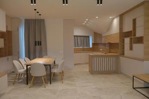 a kitchen and dining room with a table and chairs at Complex SamElyon Residence in Samokov +26 photos
