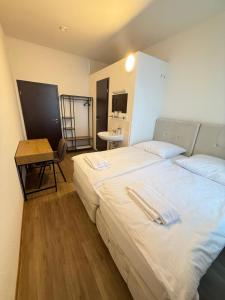 a bedroom with two beds and a table in it at Gästehaus E&E in Nierstein