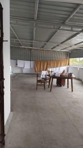 a large room with a table and benches in it at Rgn Residency in Singānallūr