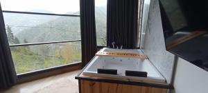 a stove in a room with a large window at Merze Suit Otel in Çamlıhemşin
