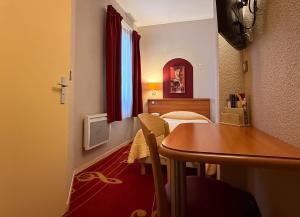 a small room with two beds and a table in a room at Hotel de L'Opéra in Bordeaux