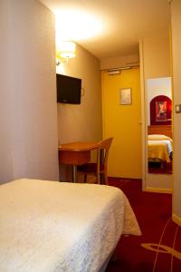 a hotel room with a bed and a desk and a room at Hotel de L'Opéra in Bordeaux +33 photos