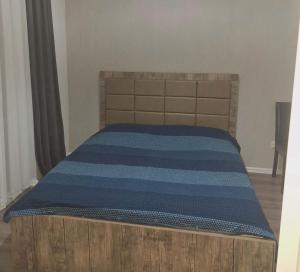a bedroom with a bed with a wooden head board at ბინა მახინჯაურში in Makhinjauri