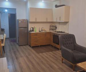 a kitchen with a refrigerator and a table and a chair at ბინა მახინჯაურში in Makhinjauri